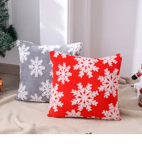 Primer plano de fundas de cojín navideñas con bordado de copos de nieve en rojo y gris.