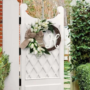 Detailweergave van kunstmatige tulpenkrans met jute strik en witte letter H decor