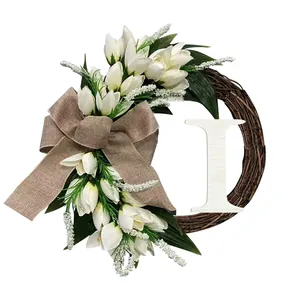 Detail van een decoratieve krans met witte tulpen en een houten letter I accent