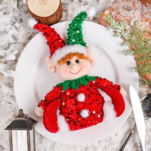 Cute sequin Christmas elf doll sitting on a white plate for festive table decoration.