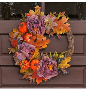 Detailansicht eines Herbstkranzes mit lila Pfingstrosen und orangefarbenen Kürbissen