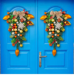 Decorative Christmas teardrop wreaths with golden ornaments and burlap bows on blue doors