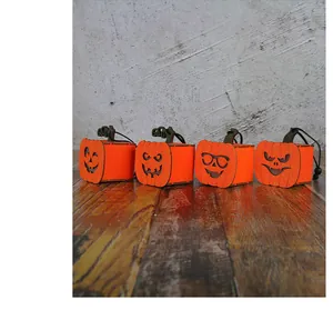 Detailansicht von vier orangefarbenen Halloween-Kürbislaternen mit Glitzer und Gesichtern