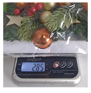 Weight measurement of a 285g Christmas garland with red berries and decorative gold ball ornaments