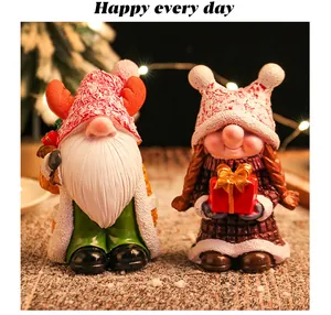 Detailed view of two festive Christmas gnome figurines featuring textured hats and a red gift box