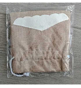 Close-up of a Christmas burlap wine bag with Santa beard detail in clear packaging