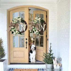 Kunstmatige tulpenkrans met letter N op een houten voordeur met een schattige hond