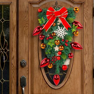 Festive Christmas teardrop wreath with large red bow and gold ornaments for door hanging