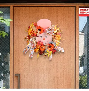 Detailed view of autumn scarecrow wreath with pumpkins and sunflowers on a wooden door