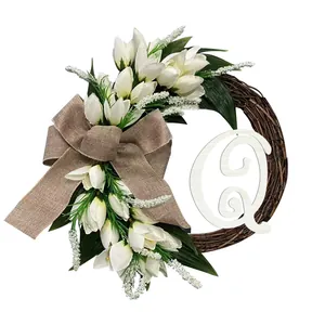 Elegante witte tulpenkrans met decoratieve houten letter Q voor de deurversiering