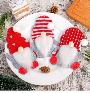 Three festive Christmas gnome felt cutlery holders set on a white plate