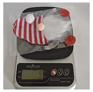 Digital scale showing the 9-gram weight of a red and white Christmas gnome felt cutlery holder