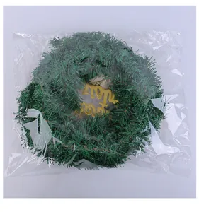 Primer plano de corona de Navidad verde artificial en bolsa de plástico protectora
