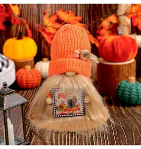 Detail of a fall harvest gnome with an orange knitted hat and fuzzy beard decoration