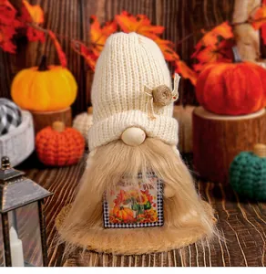 Detail of knitted Harvest Festival gnome doll with faux fur beard and pumpkin card.