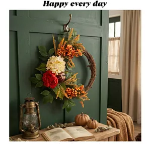 Detail of an autumn harvest wreath featuring red flowers and orange berries on a vine ring.