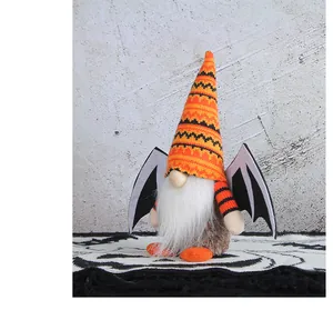Detalle de gnomo de Halloween con gorro de punto naranja y alas de murciélago
