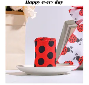 Close-up of red and black polka dot ladybug ribbon roll and bow for gift wrapping