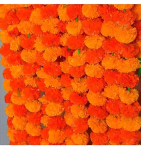 Primo piano di ghirlande dense di fiori di tagete artificiali arancioni per decorazioni di feste