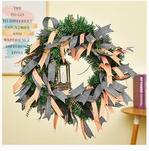 Vue détaillée d'une couronne de Noël décorée de rubans à carreaux orange et noirs