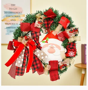 Gros plan d'une couronne de Noël festive ornée de rubans rouges et d'un visage de Père Noël mignon