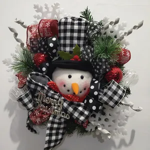 Gros plan d'une couronne de Noël festive avec bonhomme de neige et rubans à carreaux noir