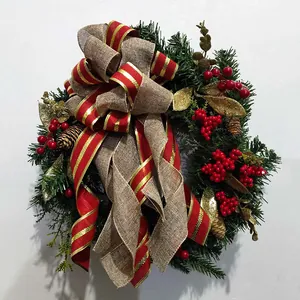 Détail d'une couronne de Noël festive avec un grand nœud rouge et des baies rouges