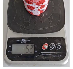 Detailed shot of a ladybug patterned decorative ribbon roll being weighed on a digital scale