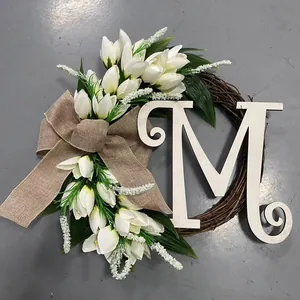 Detail van alfabetkrans met witte tulpen, jute strik en een grote houten letter M