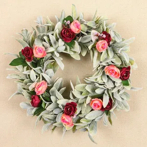 Detailed view of handmade lamb's ear grass wreath with red and pink artificial roses.