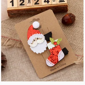 Set of festive Christmas hair clips featuring Santa and stocking on display card