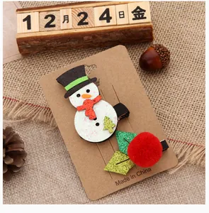 Detailed view of festive Christmas hair clips featuring snowman and red pom-pom designs