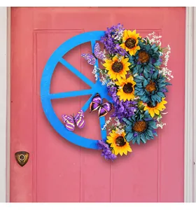 Blue sunflower wagon wheel wreath hanging on a pink door for spring home decoration