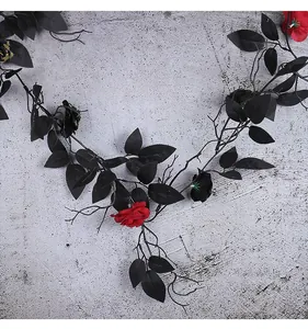 Close-up view of black Halloween vine decoration with realistic black leaves and red roses
