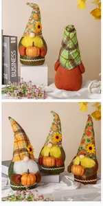 Dettaglio di gnomi autunnali in peluche fatti a mano con decorazioni di zucche e fiori