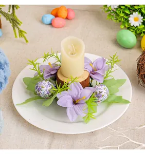 Close-up of Easter candle holder with purple lilies, patterned eggs and a pillar candle
