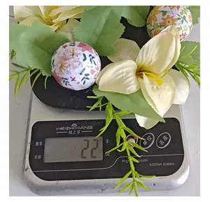 Detailed weight measurement of a floral Easter egg decorative ornament on a digital scale