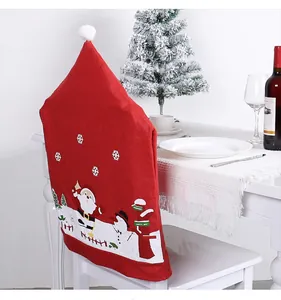 Festive red non-woven Santa Claus chair cover on a white chair with holiday decor