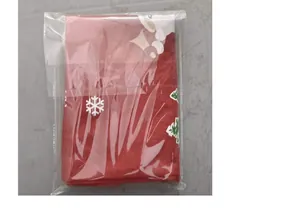 Red non-woven Christmas chair cover with snowflake print in clear plastic packaging.