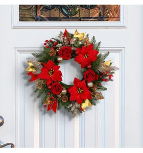 Ghirlanda natalizia con stelle di Natale rosse, rose e accenti dorati su porta.