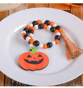 Détail d'une guirlande de perles en bois d'Halloween avec citrouille et gland