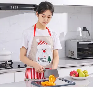 Asian model wearing a festive Christmas Santa Claus linen apron in a modern kitchen