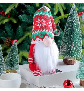 Detail shot of a handmade Christmas gnome with a red and green knitted snowflake hat