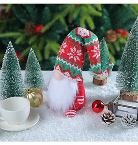 Detailed view of a festive Christmas gnome with a long knitted snowflake hat in a snowy scene.