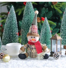 Detail view of cute plaid snowman plush toy in a festive Christmas scene with snow
