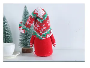 Festive Christmas gnome with knitted snowflake hat standing on a holiday display shelf