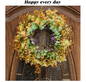 Detailed view of a colorful artificial spring wildflower wreath hanging on a wooden door