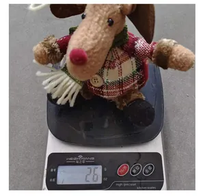 Christmas reindeer plush ornament being weighed on a digital scale showing 26 grams