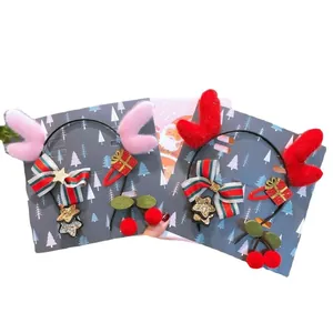 Leuke kersthaaraccessoireset met pluche rendiergewei en feestelijke strikken op kaart.