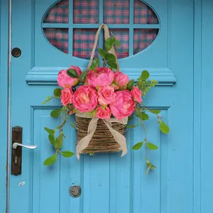 Beautiful artificial pink rose flower basket hanging on a blue vintage wooden door decoration